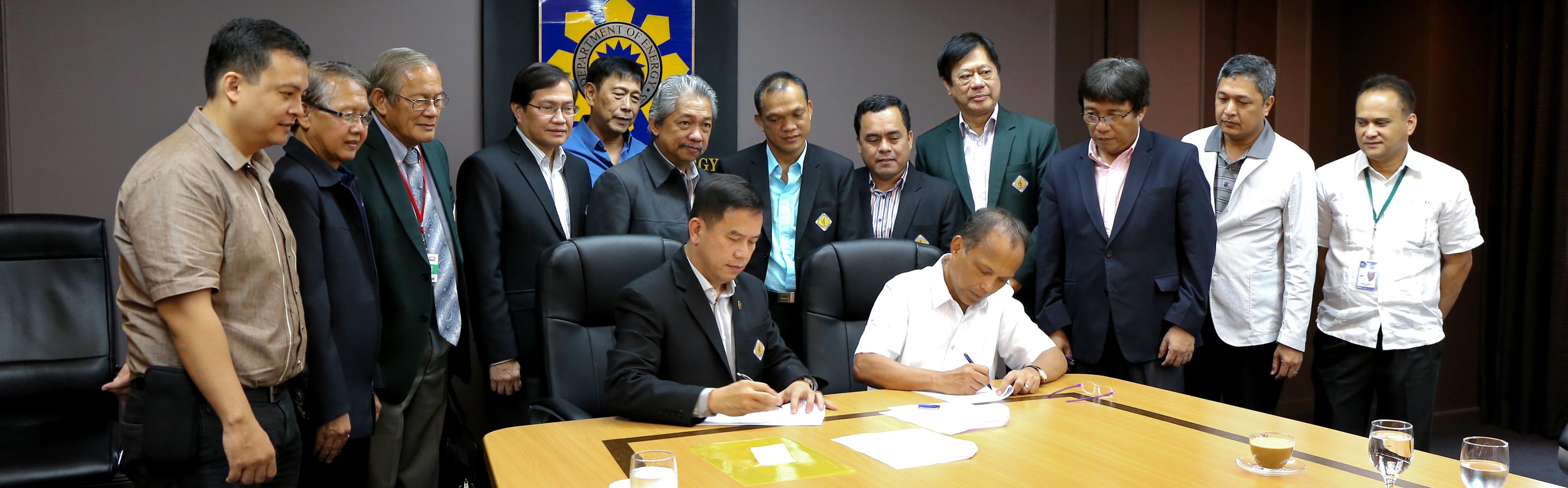 A signing ceremony between DOE and IIEE for the technical audit of the country's power system: generation, transmission and distribution utilities.